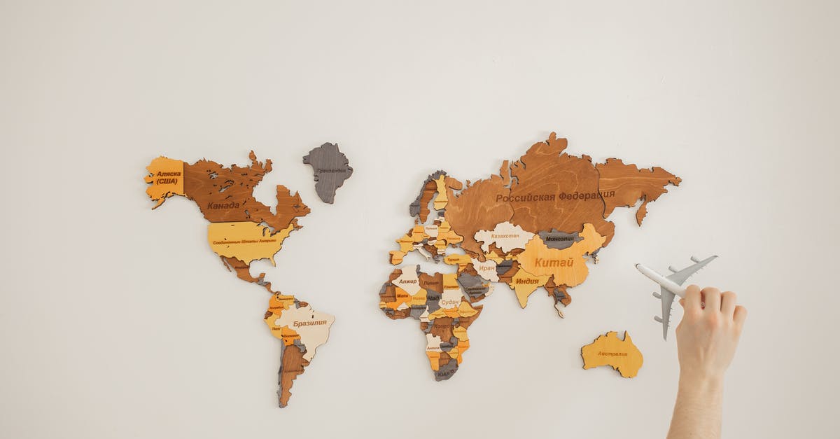 Vim Adventures- Level 7 - Stuck on: What's in a name - Crop anonymous traveler with toy aircraft over decorative wooden world map with country names on white background in light room