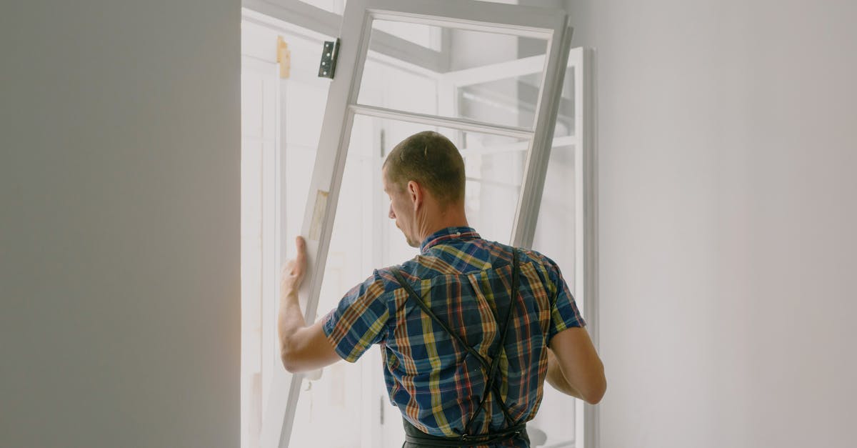 Visiting New Zealand, unable to install - Unrecognizable workman installing window in house during renovation process Visiting New Zealand, unable to install - Unrecognizable workman installing window in house during renovation process