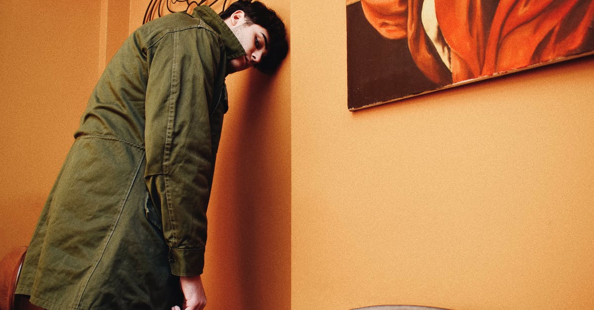 Wall breaker vs Giant against walls - Young Man in Coat Leaning His Forehead Against Wall in Cafeteria