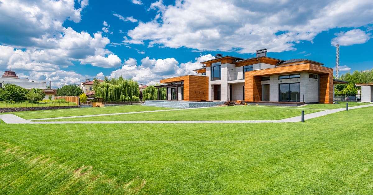 Wall of Flesh Glitch or Bug - Exterior of modern residential house with wooden walls and green grass growing in yard against blue sky with white clouds