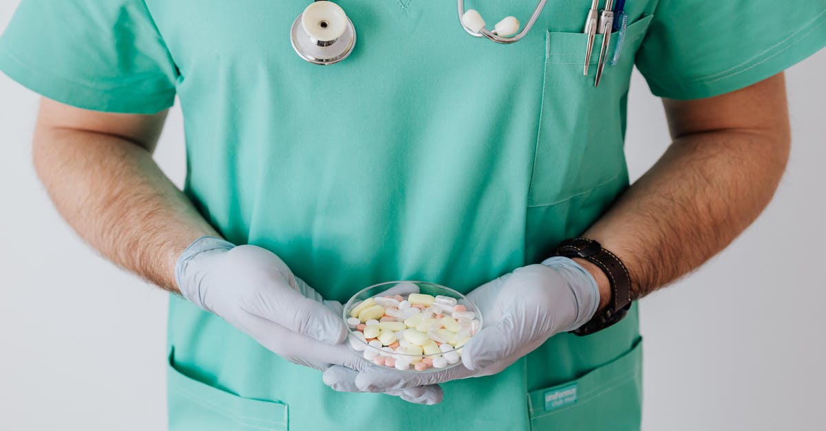 Wand and a staff differences in Portal Knights - Unrecognizable male doctor wearing medical uniform and latex gloves holding Petri dish filled with assorted drugs while standing near white wall in hospital