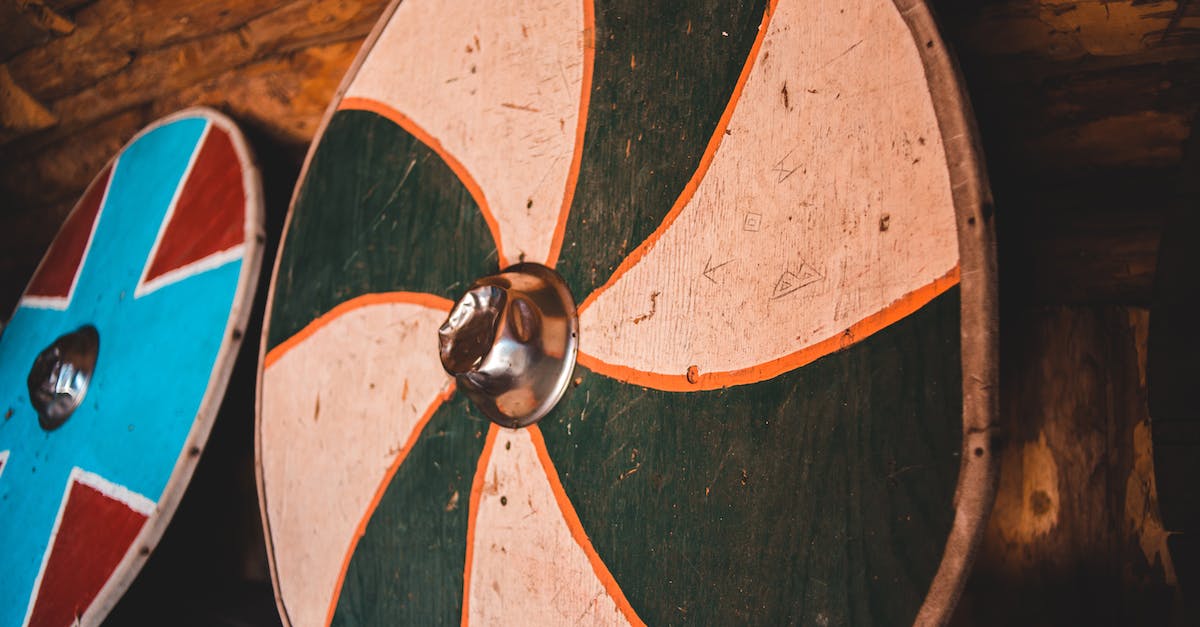 Warrior Shield Slam Glyph - From below of various shabby circular Viking shields hanging on wall in aged wooden museum in Norstead