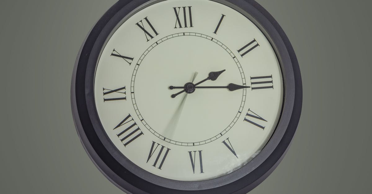 Watch won't show time - Round black mechanical clock with Roman numerals hanging on gray wall Watch won't show time - Round black mechanical clock with Roman numerals hanging on gray wall