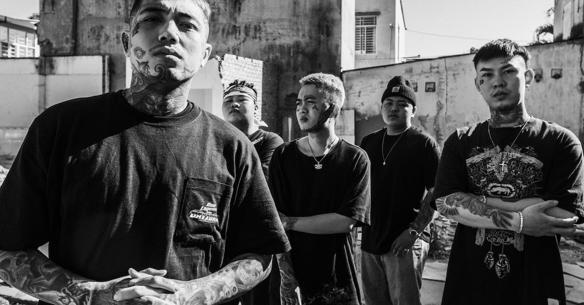 Watch_dogs gang hideouts don't appear - Black and white of young tattooed ethnic males of band in accessories and casual apparel in town