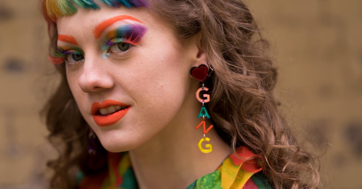 Watch_dogs gang hideouts don't appear - Young eccentric female with rainbow bang and makeup in trendy clothes and gang letter earrings standing on street and looking at camera