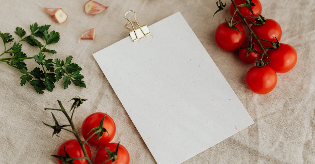 Weird golden moths flitting around my head in Skyrim Dragonborn - Top view of blank clipboard with golden paper binder placed on linen tablecloth among tasty red tomatoes on branches together with chopped garlic head and green parsley ideal for recipe or menu