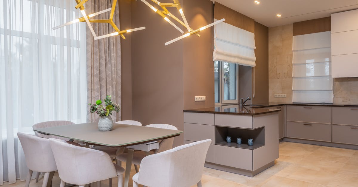 What's more eco-friendly: Steel furnaces or Electric furnaces? - Contemporary open plan kitchen with gray matte cabinets and dining table under contemporary geometric lamp in spacous apartment