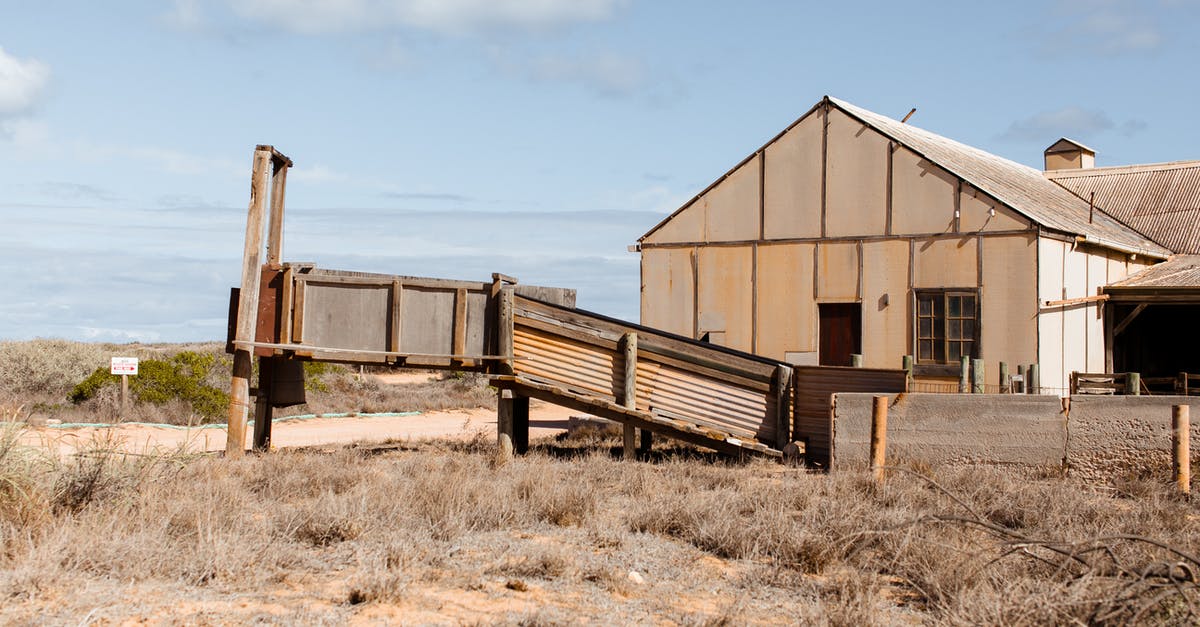 What's the benefit of destroying abandoned dwellings? - Exterior of old shabby house with rusty fence located on sandy terrain covered with dry grass against blue sky on sunny day What's the benefit of destroying abandoned dwellings? - Exterior of old shabby house with rusty fence located on sandy terrain covered with dry grass against blue sky on sunny day