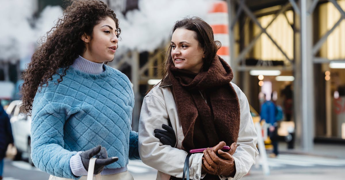 What's the best way to get rich? - Positive stylish multiethnic women talking and crossing road in city