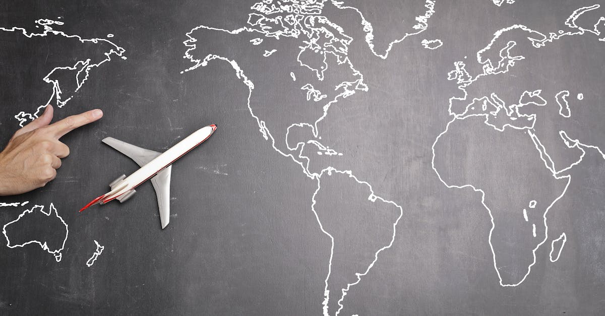 What's the cheapest way to achieve the salvaging monthly requirement? - Top view of miniature airplane placed on over gray world map with crop hand of anonymous person indicating direction representing travel concept