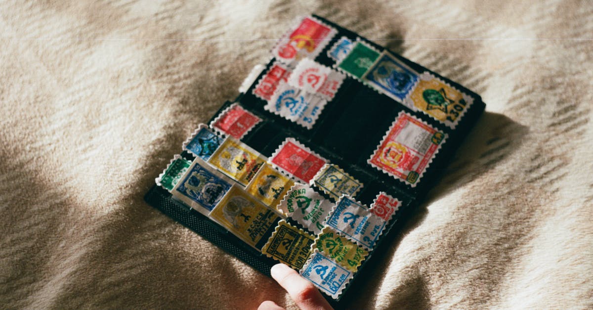 What's the difference between a soft reload and a hard reload in first person shooters? - From above of crop unrecognizable person with collection of vintage stamps with illustrations on woolen textile