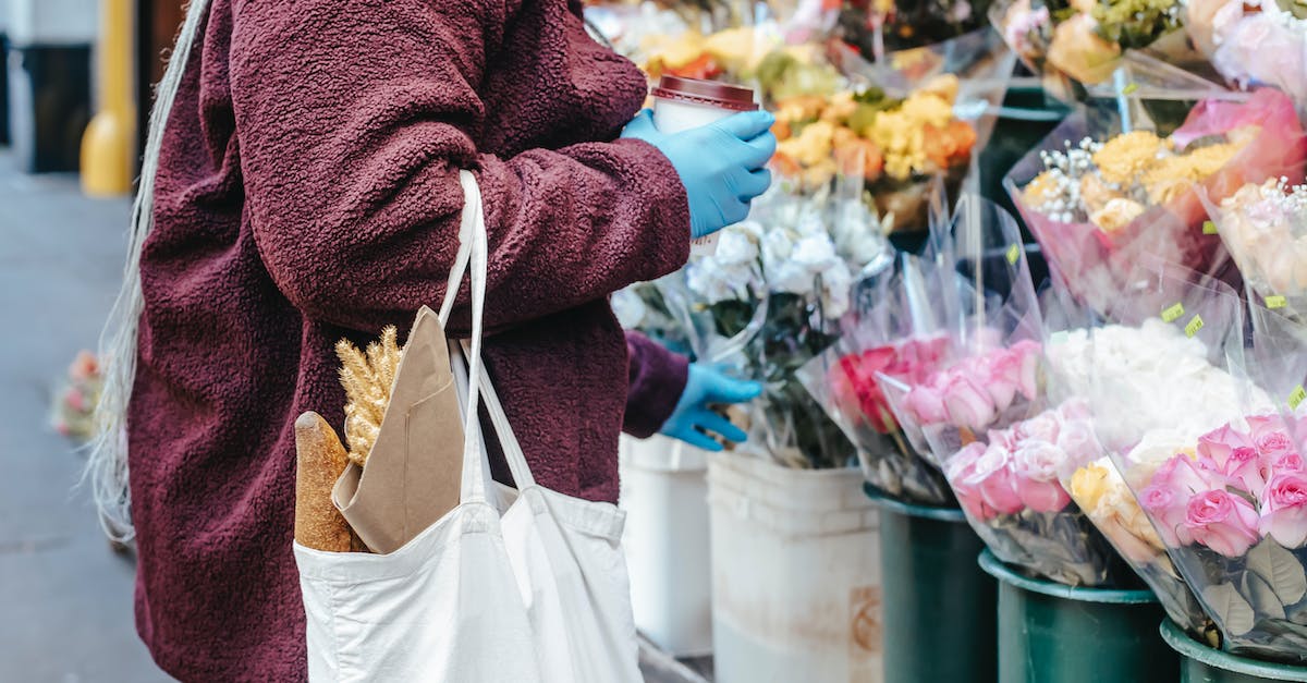 What's the difference between different priced chests? - Woman with paper cup of coffee buying flowers on street