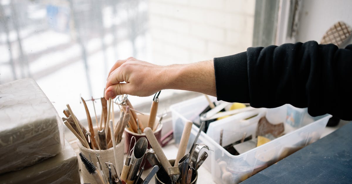 What's the difference between GOG and Steam? [closed] - Close-up of a Person Choosing a Tool in an Art Studio
