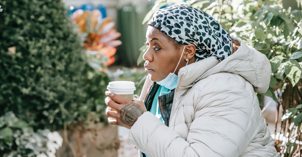 What's the maximum amount of side quests you can complete in Majora's Mask in a 3 day cycle? - Side view of serious adult black woman in nurse uniform with protective mask and jacket with headwear drinking coffee in street in sunny day near green plants