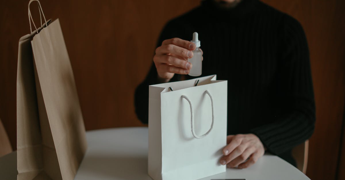 What's the most efficient order in which to check for discrepancies? - Focused man pulling out beauty product from shopping bag at table