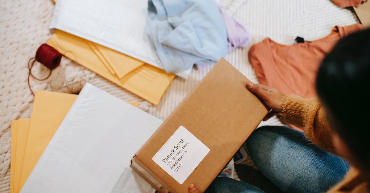 What's the most efficient order in which to check for discrepancies? - Top view of crop anonymous female with carton box of parcel checking address among envelopes