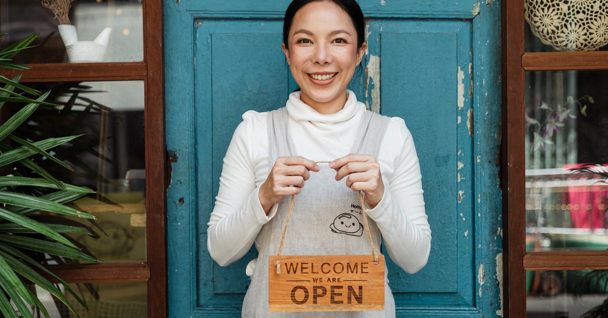 What's the original cardboard cartridge inlay for Pokemon Red/Blue? - Cheerful ethnic female cafeteria owner in apron demonstrating cardboard signboard while standing near blue shabby door and windows after starting own business and looking at camera