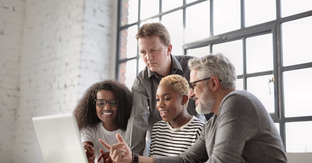What's the point of different cooldowns for the powers? - Group of multiracial colleagues laughing and pointing to screen of laptop while sitting at table and working on project in modern workplace