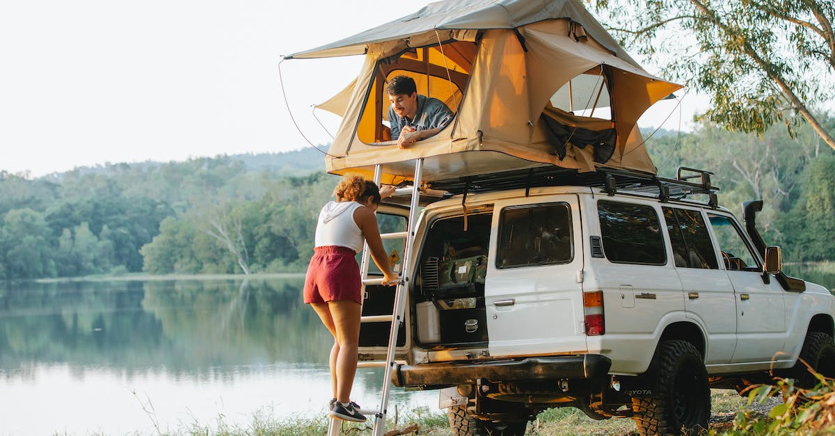 What activates auto fire? - Unrecognizable woman standing on ladder near boyfriend recreating in tent during camping at lakeside What activates auto fire? - Unrecognizable woman standing on ladder near boyfriend recreating in tent during camping at lakeside