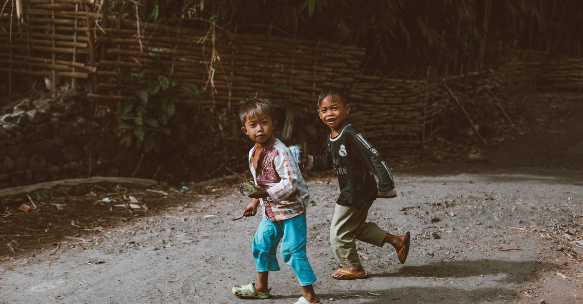 What affects settlement happiness? [duplicate] - Full body of little ethnic children walking on dirty path near green plants in village on sunny day