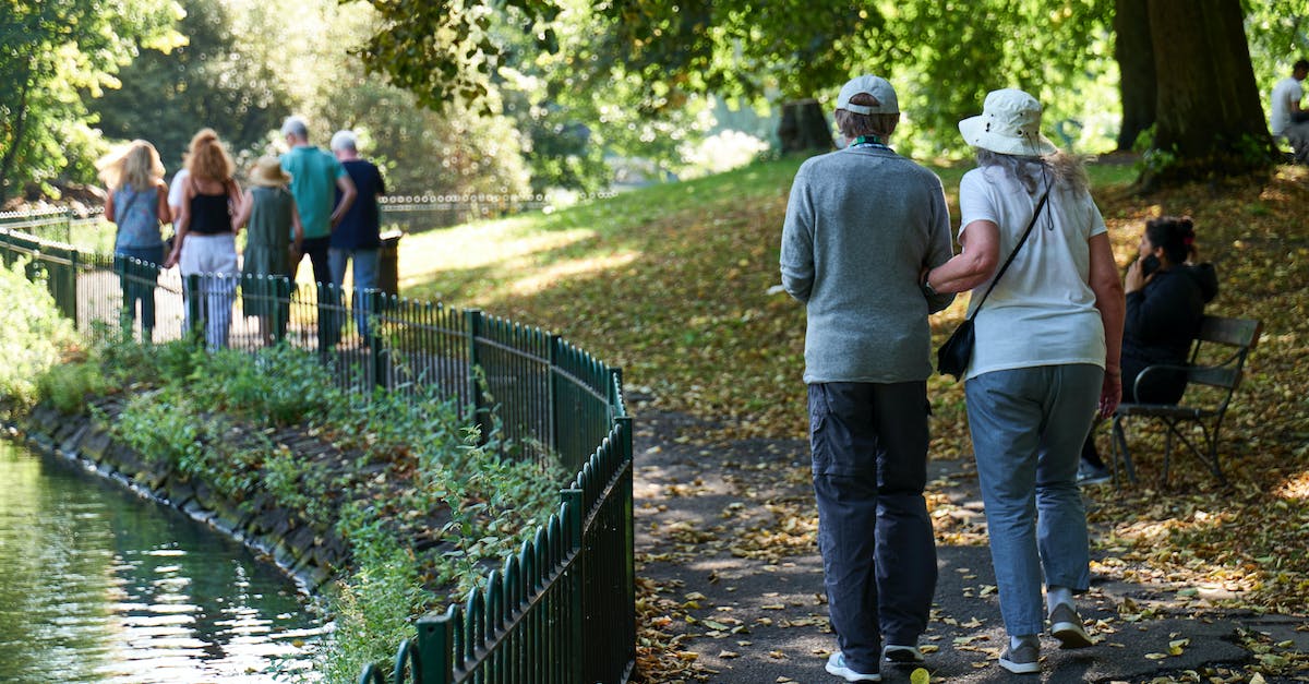 What affects the path of the ball after impact? - Anonymous couple walking along pond in park What affects the path of the ball after impact? - Anonymous couple walking along pond in park