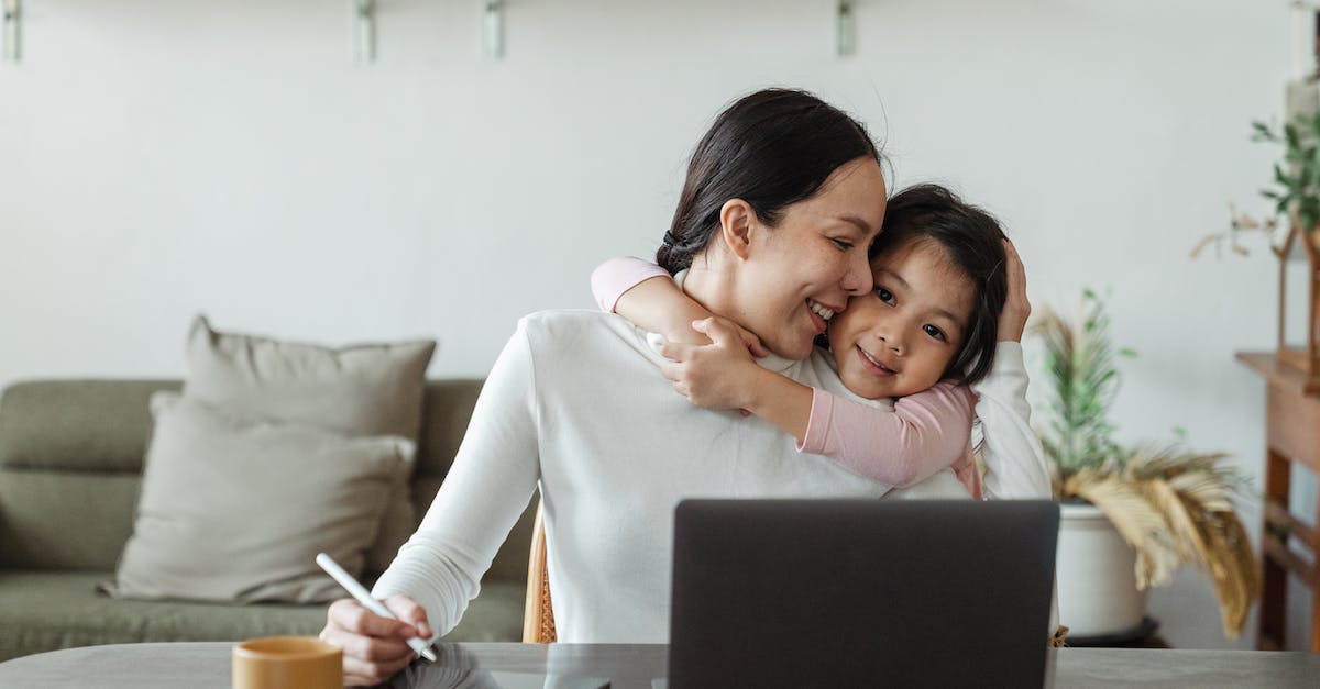 What affects when someone uses my pawn? - Happy young Asian woman working remotely from home with laptop and tablet while adorable little daughter hugging from behind