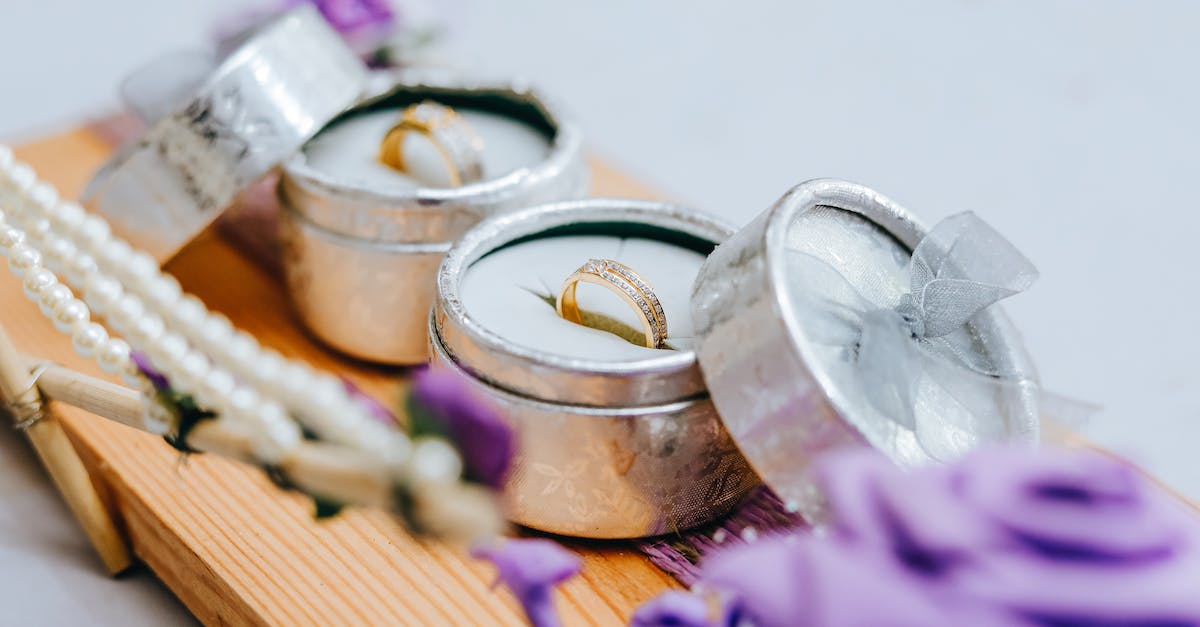 What are all the pokemon pearl ribbons? - Golden wedding rings in small grey boxes on wooden stand with purple flowers