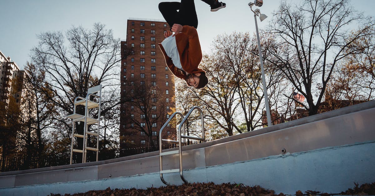 What are Dynamic Shadows? - Sportsman performing back flip against city park