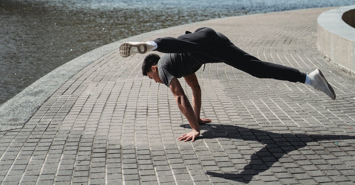 What are Dynamic Shadows? - Unrecognizable ethnic dancer showing trick standing on hands in town
