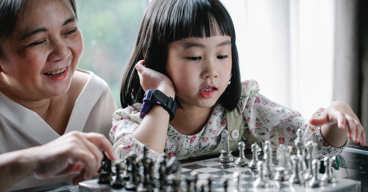 What are effective strategies for countering Mind Control? - Adorable ethnic child doing move while playing chess with grandmother