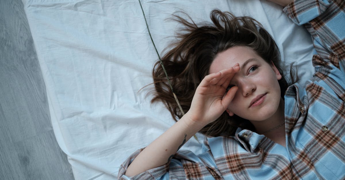 What are floors made of? - Girl in Blue White and Red Plaid Button Up Shirt Lying on Bed