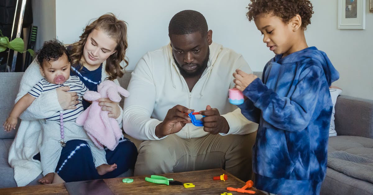 What are "torrents" in relation to gaming? - Black kid playing toys with father sitting on sofa near wife hugging cute baby while spending time together