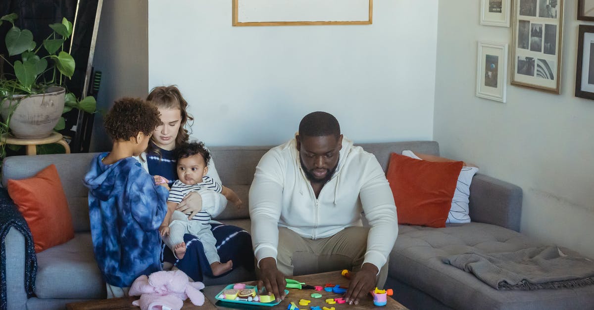 What are "torrents" in relation to gaming? - Black father playing toys sitting near wife cuddling baby and son while spending free time together at home What are "torrents" in relation to gaming? - Black father playing toys sitting near wife cuddling baby and son while spending free time together at home