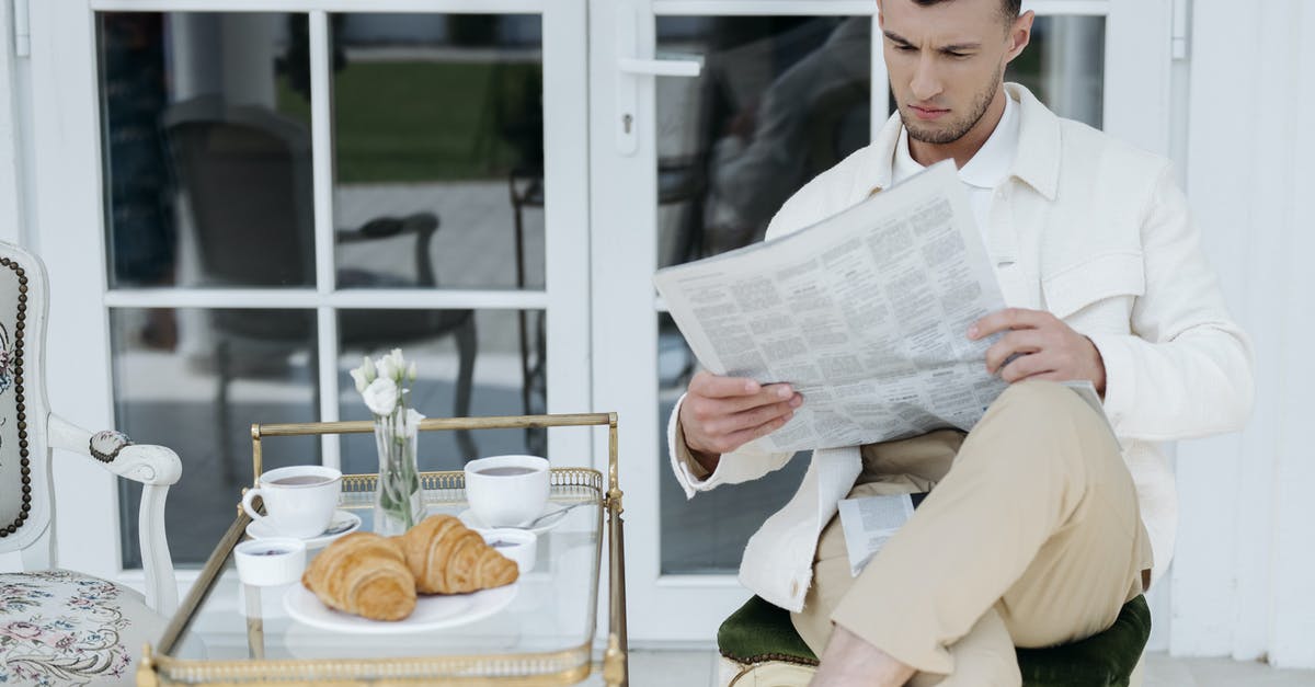 What are some good foods for the winter? - A Man Reading Newspaper while Sitting Near the Serving Cart with Coffee and Breads