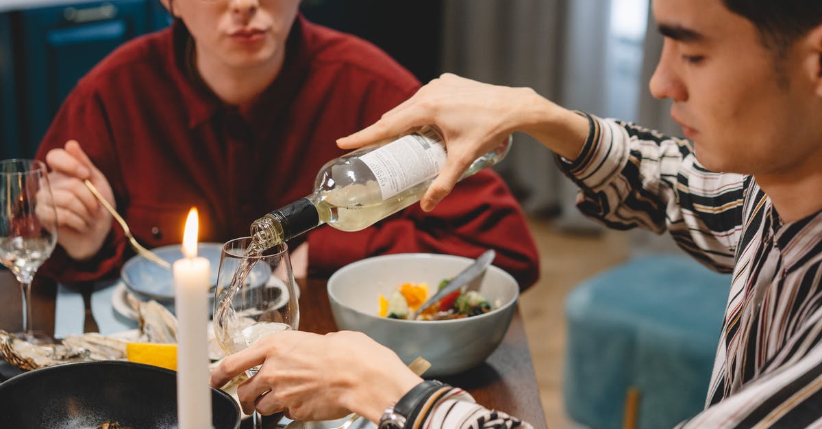 What are some good foods for the winter? - A Man Pouring a White Wine in a Glass
