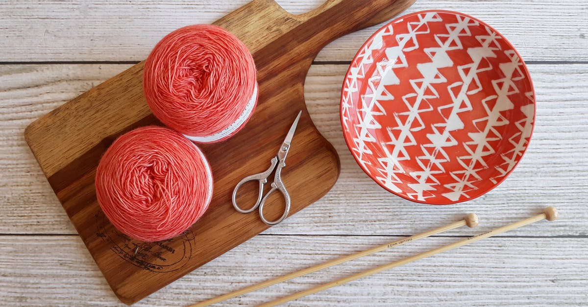 What are the balls of yarn for? - Two Pink Spools on Brown Wooden Chopping Board Beside Orange Bowl 
