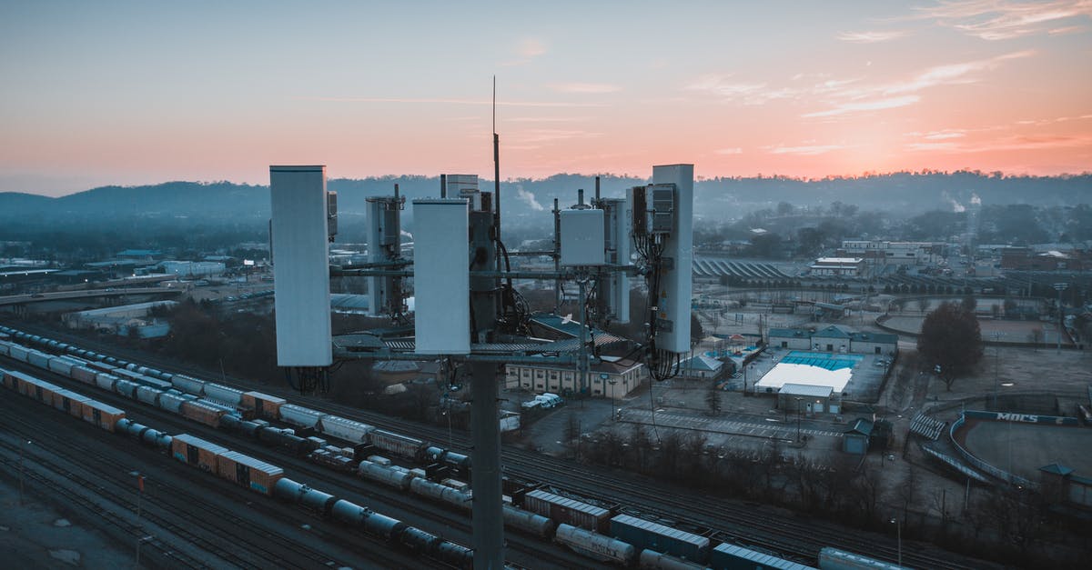 What are the benefits of having a cargo freight station? - Drone view of contemporary cell tower located near railway tracks with cargo containers and wagons against sunset sky What are the benefits of having a cargo freight station? - Drone view of contemporary cell tower located near railway tracks with cargo containers and wagons against sunset sky