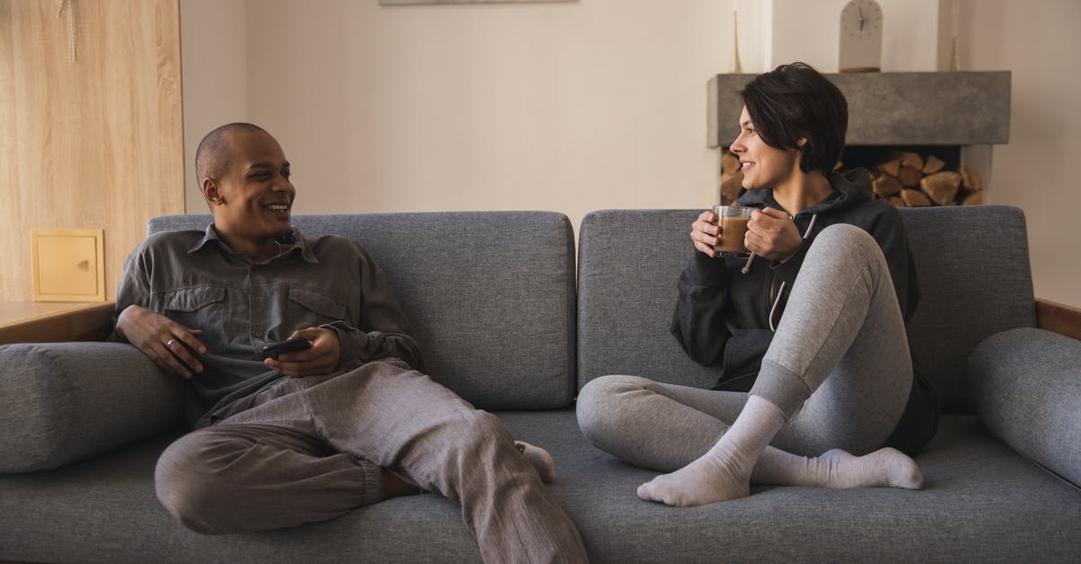 What are the benefits of using royal arms? - Happy young multiracial couple taking on sofa at home