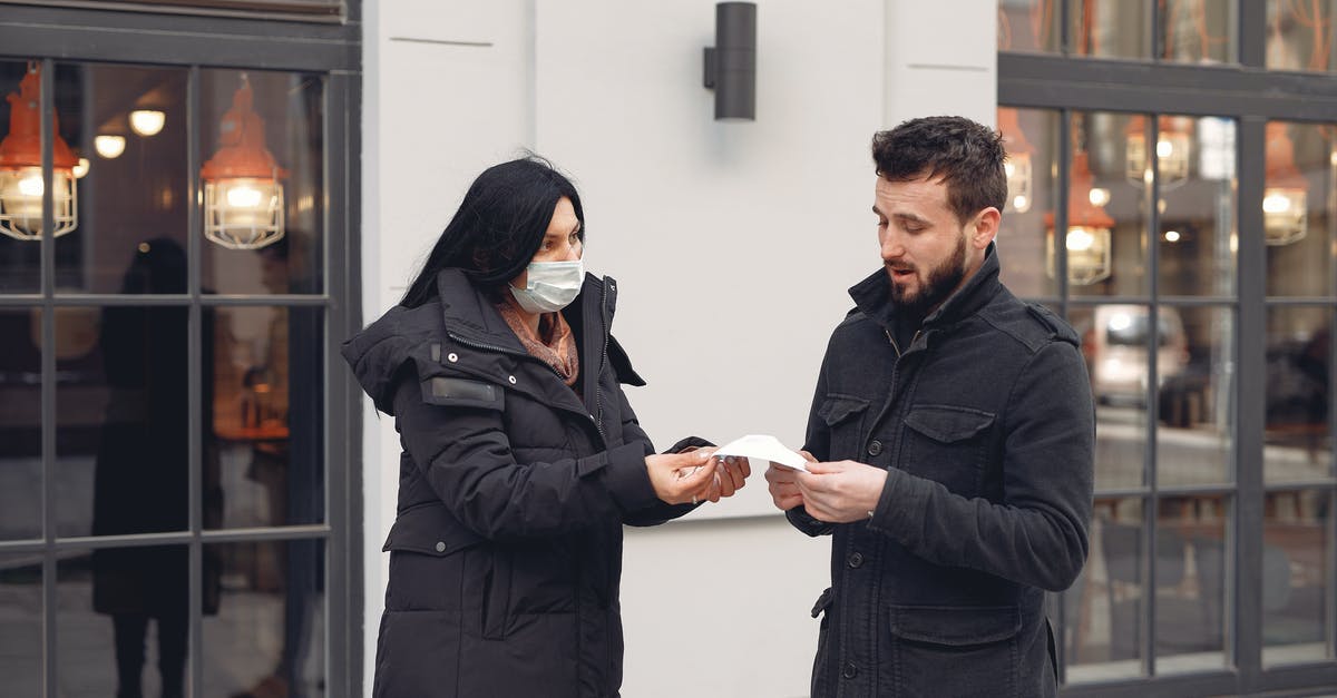 What are the chances of getting loot when giving meds to a sick man? - Careful female volunteer in black down jacket suggesting protective facial mask for bearded male pedestrian on city street in cold season during coronavirus pandemic What are the chances of getting loot when giving meds to a sick man? - Careful female volunteer in black down jacket suggesting protective facial mask for bearded male pedestrian on city street in cold season during coronavirus pandemic