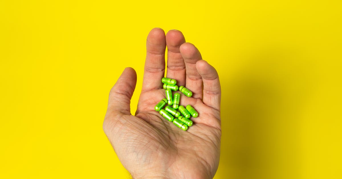 What are the chances of getting loot when giving meds to a sick man? - From above of crop unrecognizable male demonstrating green pills in hand against yellow background in daylight What are the chances of getting loot when giving meds to a sick man? - From above of crop unrecognizable male demonstrating green pills in hand against yellow background in daylight
