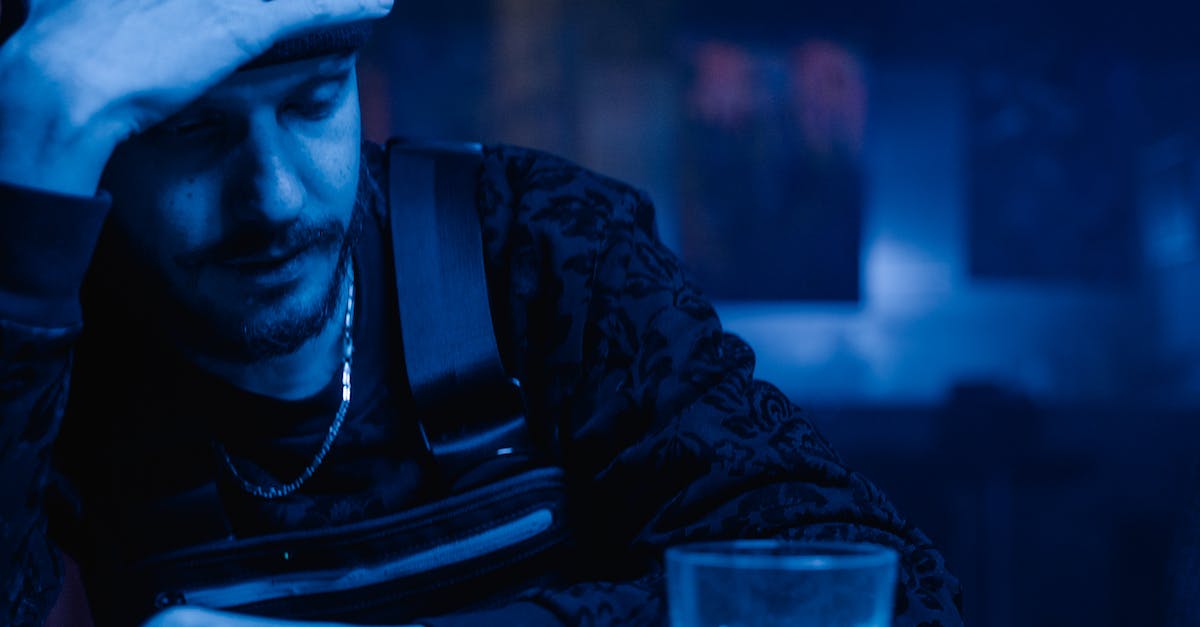 What are the consequences of excessive drinking? - Man in Black Leather Jacket Holding Clear Drinking Glass