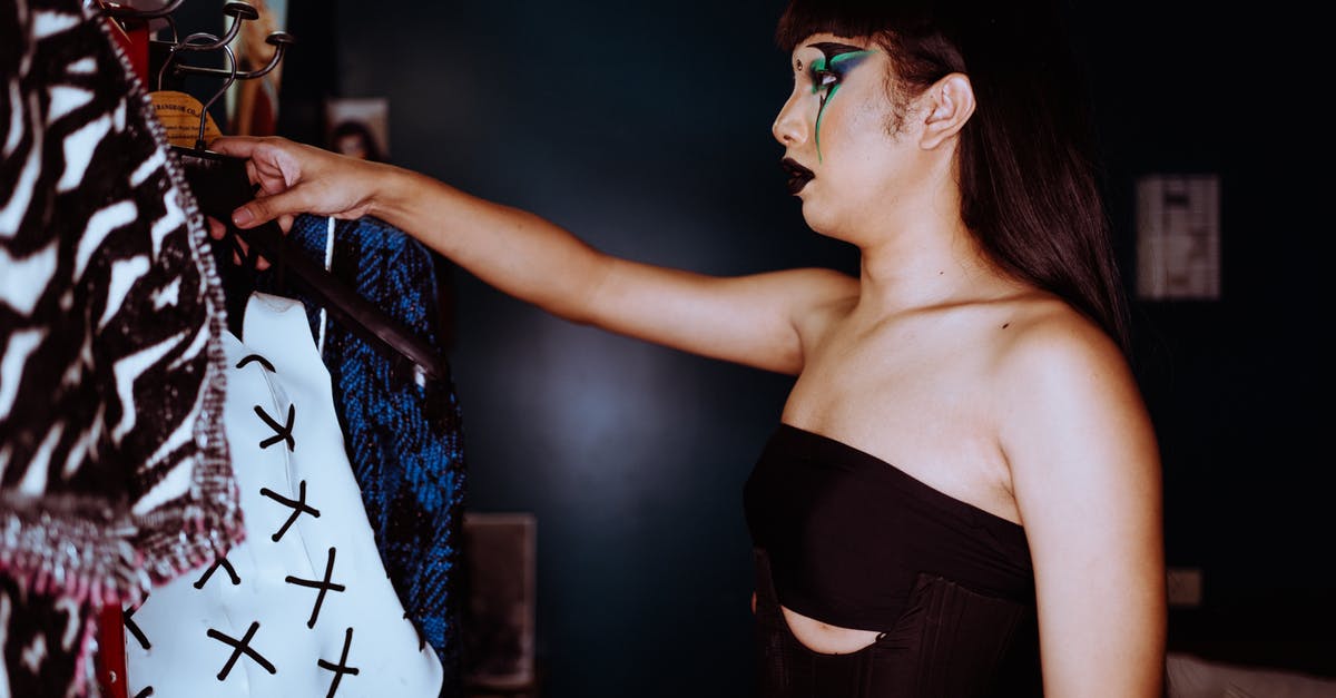 What are the effects of the various Protectron Personality Modes? - Side view of stylish Asian female with bright makeup standing near rack with various clothes and choosing outfit while standing in room What are the effects of the various Protectron Personality Modes? - Side view of stylish Asian female with bright makeup standing near rack with various clothes and choosing outfit while standing in room