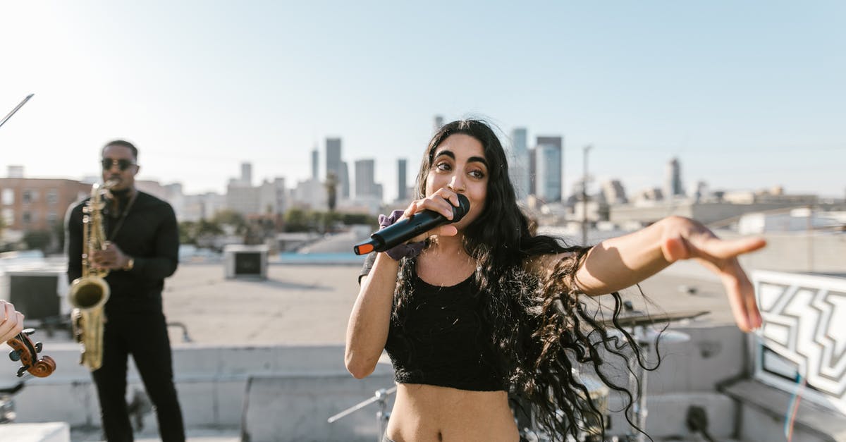 What are the graces at Weeping Peninsula pointing to? - Woman in Black Crop Top and Black Denim Shorts Holding Blue and White Labeled Bottle