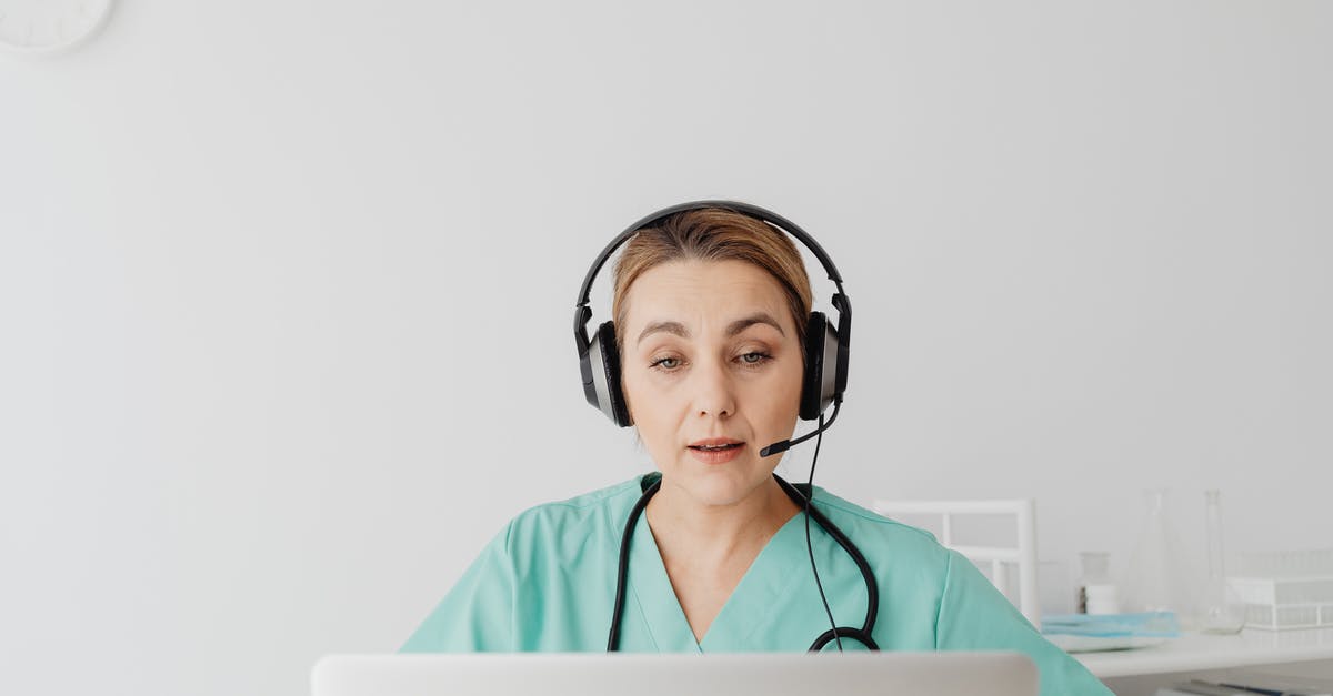 What are the people talking about? - Man in Teal Scrub Suit Wearing Headphones What are the people talking about? - Man in Teal Scrub Suit Wearing Headphones