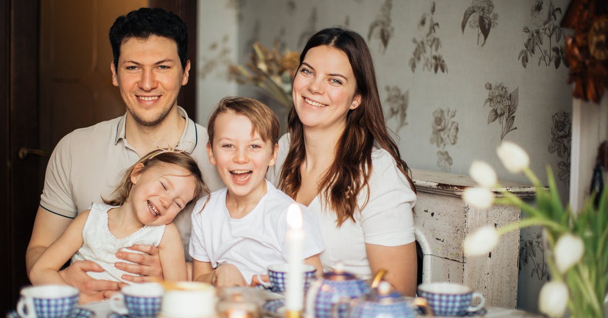 What are the positions of heroes/monsters if there are less than four of them? - Positive family in casual clothes enjoying tea with sweets sitting at table set for breakfast with candle and laughing while looking at camera