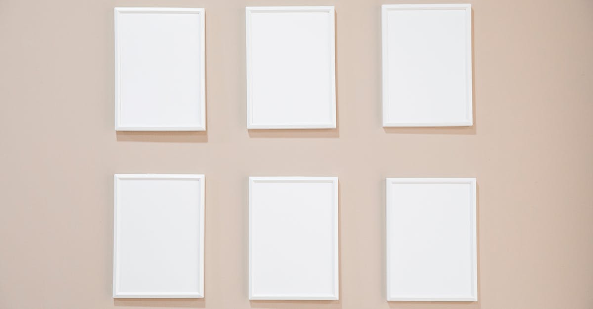 What are the rules for object positions when space is rotated in Fez? - Rows of blank white rectangular frames hanging on light pink wall in studio What are the rules for object positions when space is rotated in Fez? - Rows of blank white rectangular frames hanging on light pink wall in studio