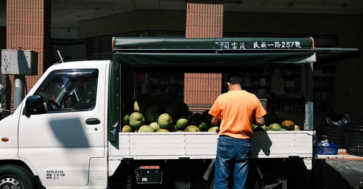 What are these pickups? - Man in Orange Shirt Standing beside White Pickup Truck