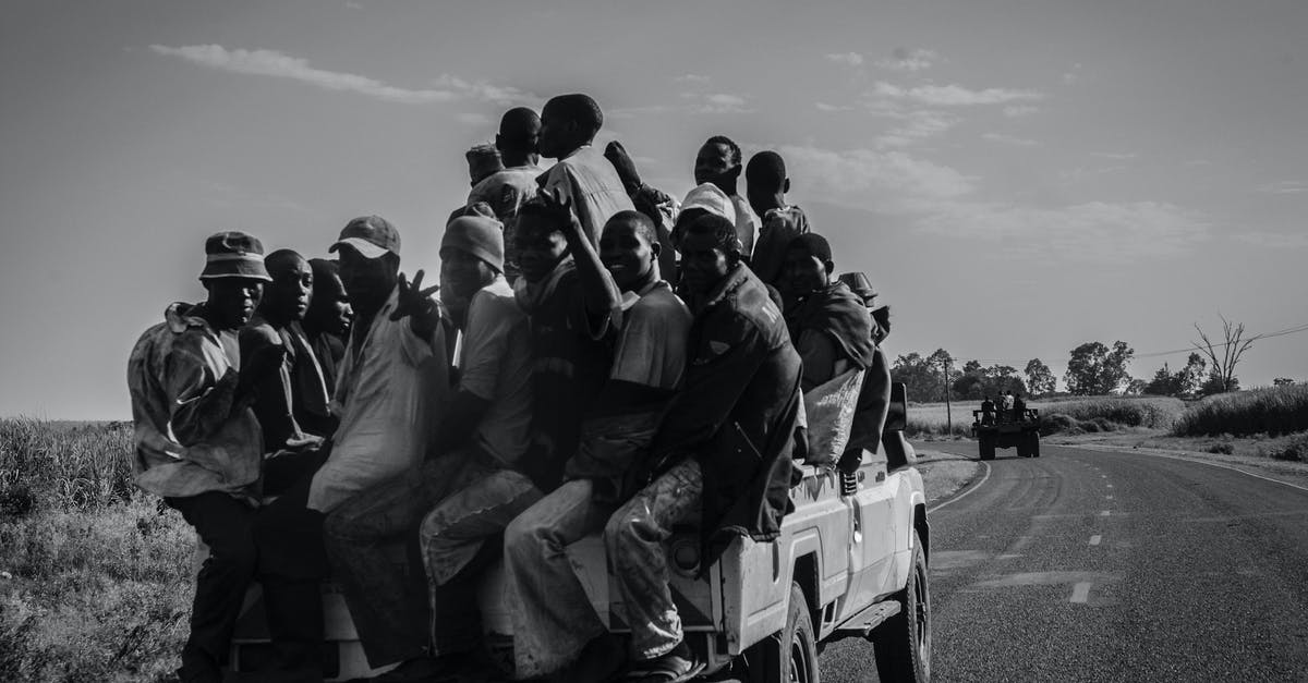 What are these pickups? - Grayscale Photo of People Sitting on Car