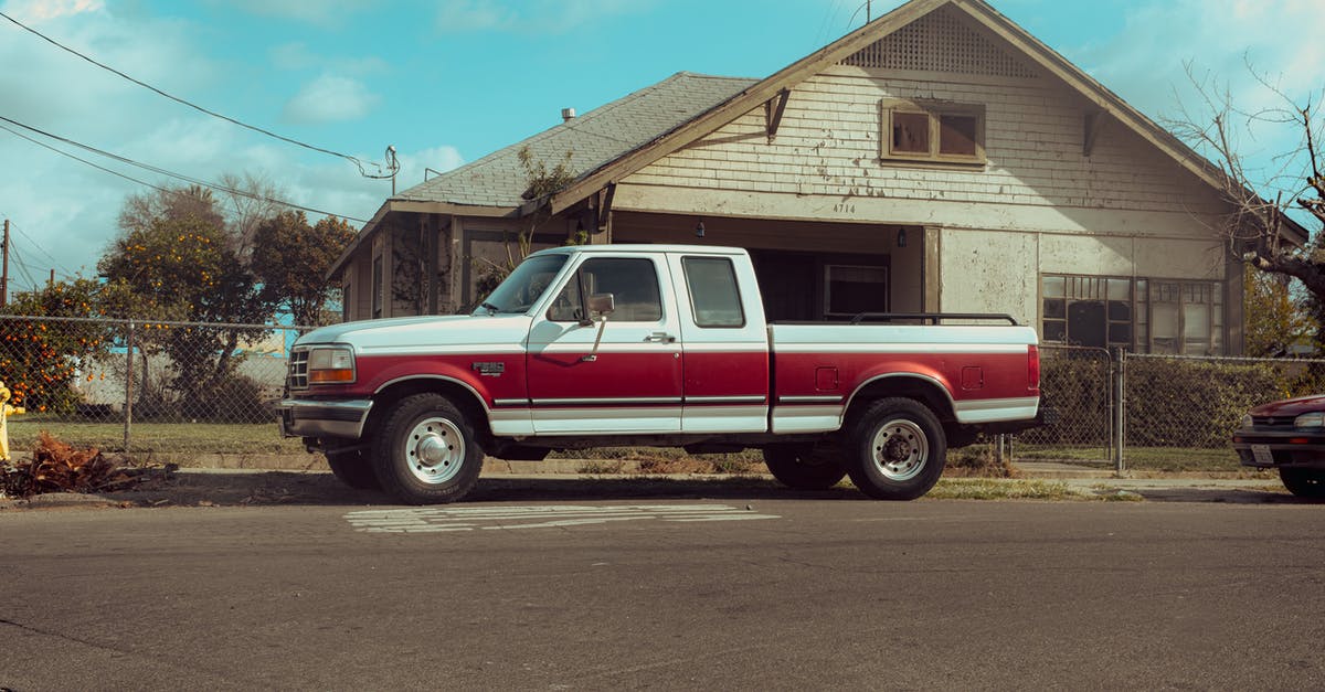 What are these pickups? - Red and White Single Cab Pickup Truck Parked Beside Brown Wooden House