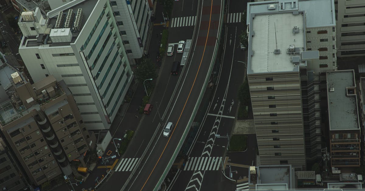 What are these weird 1 wide vertical tunnels? - Drone view of residential area in modern city with transport on asphalt roads and multistory houses
